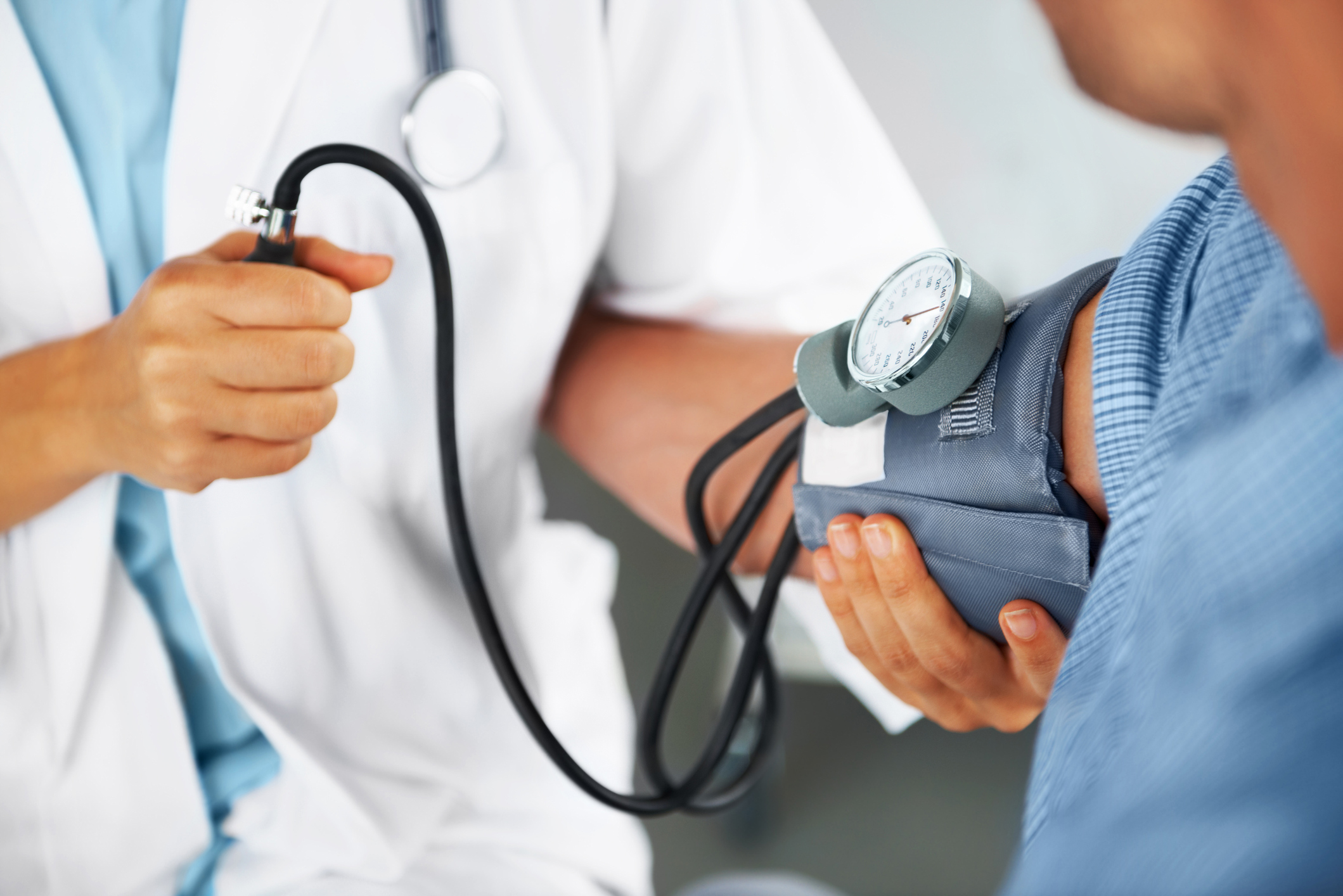 A doctor listening to his patient's heartbeat with a stethoscope A doctor listening to his patient's heartbeat with a stethoscope