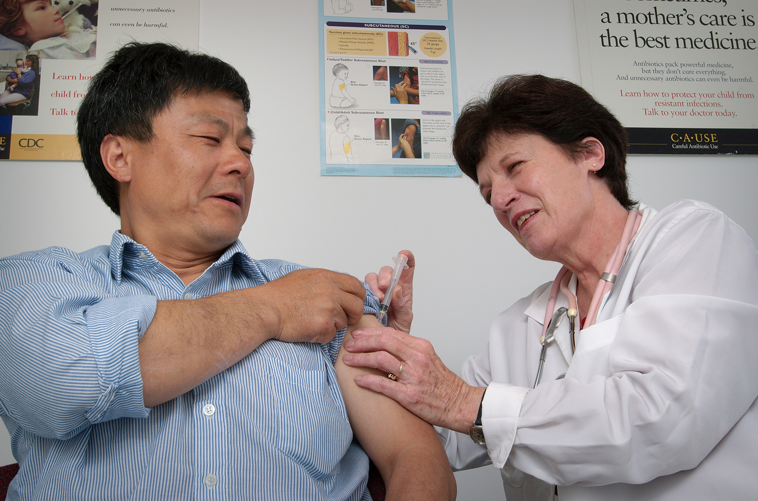 Man receiving an intramuscular immunization in his left shoulder.