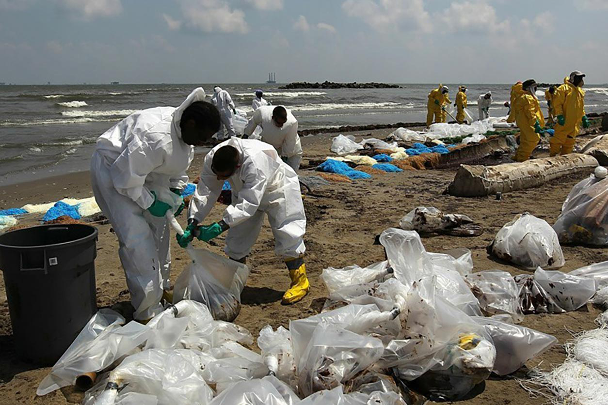 Participants from the Environmental Career Worker Training Program helping to clean up the Deepwater Horizon oil spill on a beach.