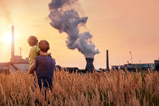 Son and father with pollution emitting building in background