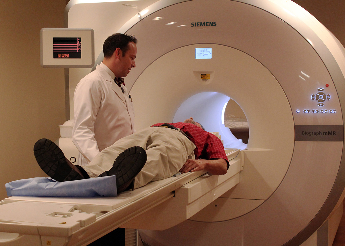 Imaging Technology Imaging technologist talks to a patient before a scan in the fully integrated whole-body simultaneous PET/MRI device.