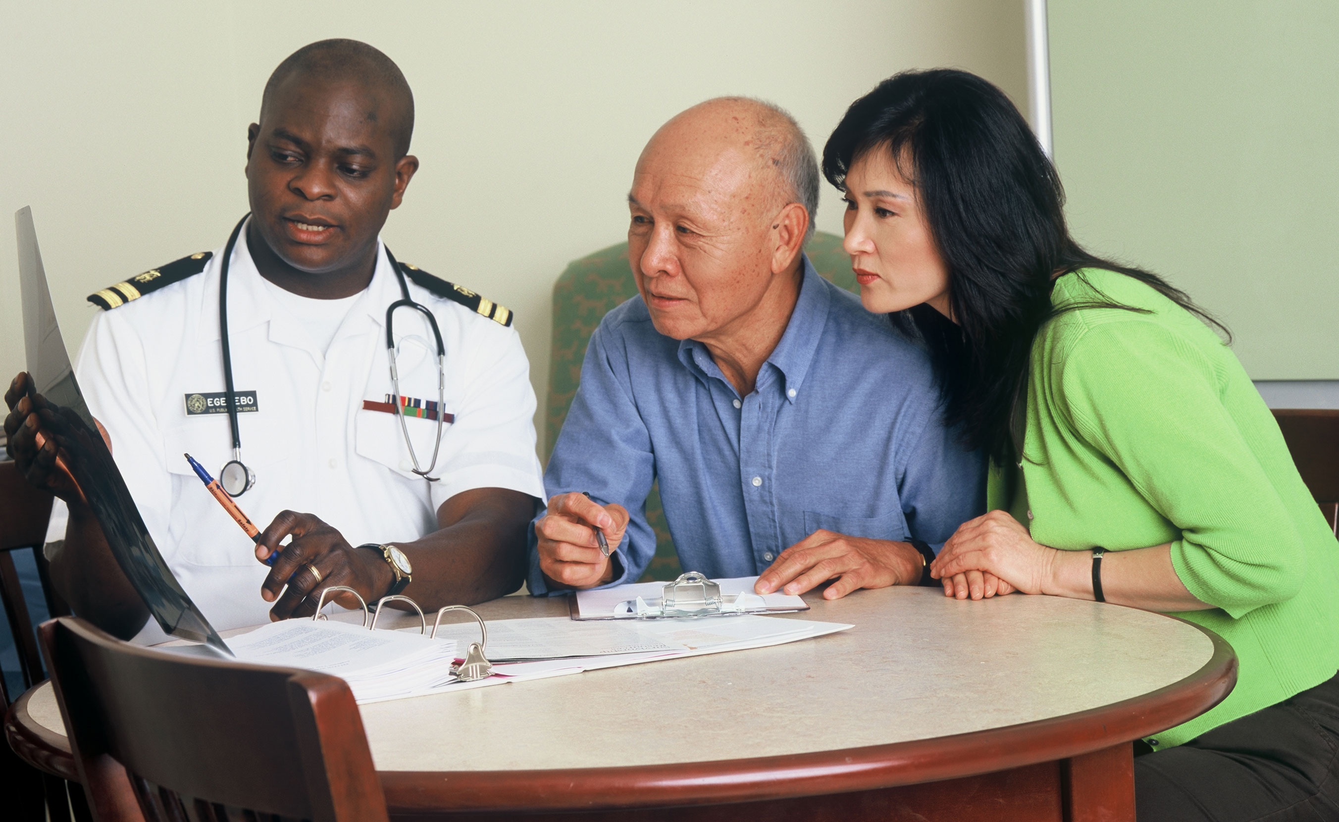 Photo of a doctor speaking with a patient and a family member.