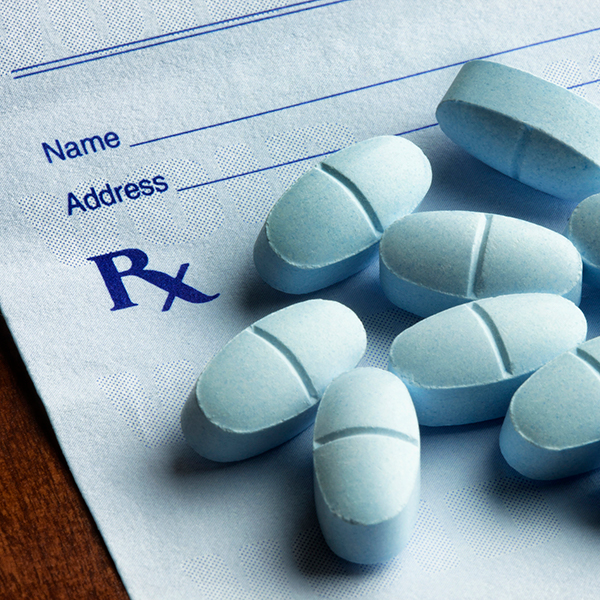 Hydrocodone with acetaminophen tablets on a prescription form.