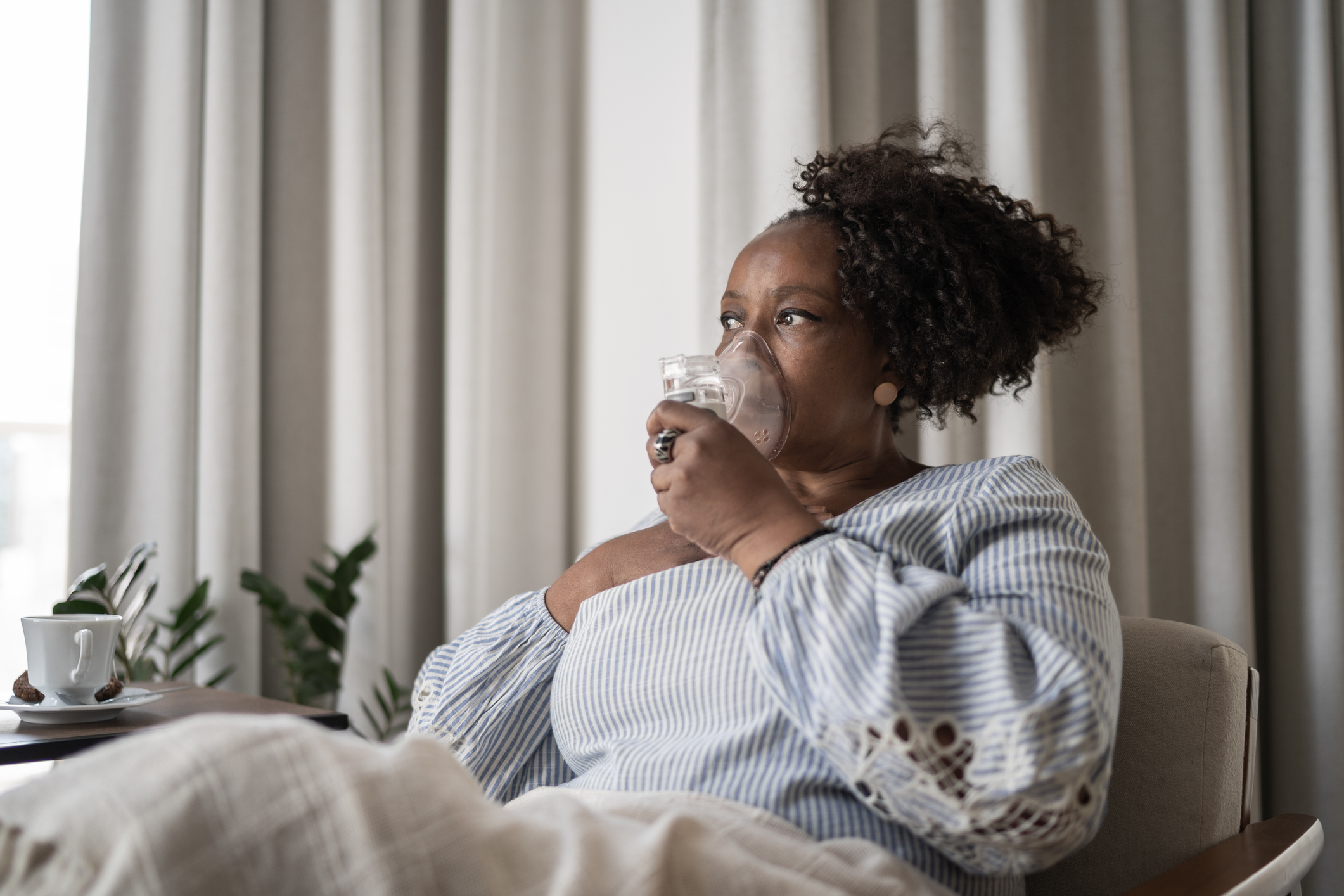 Mature woman using an inhalation mask at home