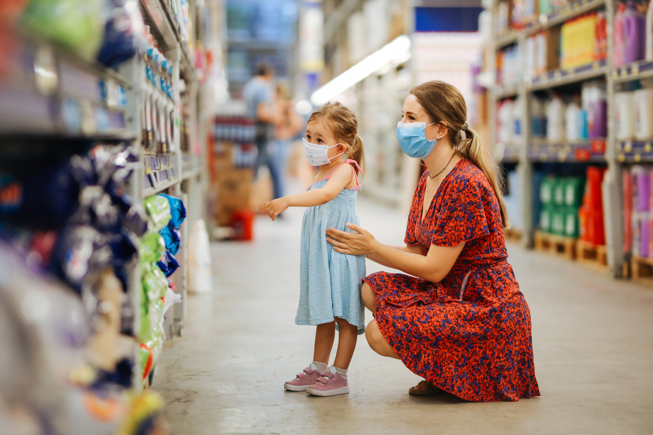 Portrait of a mature woman with her daughter wearing a protective mask shopping in a supermarket