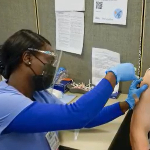 a nurse injecting a patient with the COVID-19 vaccine