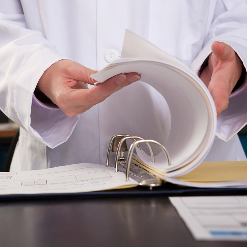 Scientist flipping through a report in the laboratory.