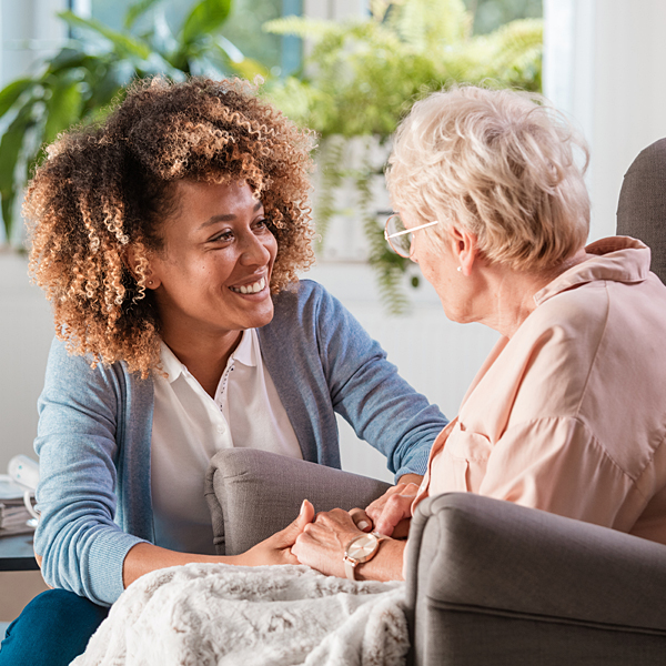 A caregiver assisting a senior woman in her home