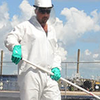 Worker cleaning up oil spill.