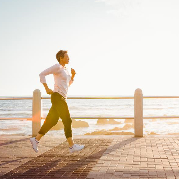 Woman jogging along the oceanfront.