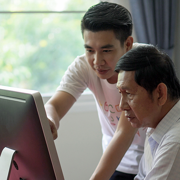A father and son looking at a computer