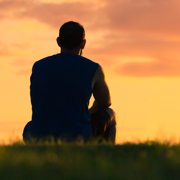 A silhouette of a man watching the sunset