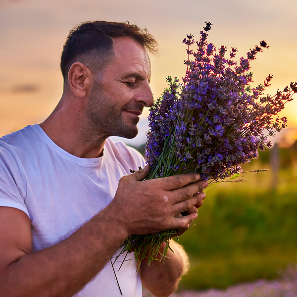 A man smelling a bundle of lavender