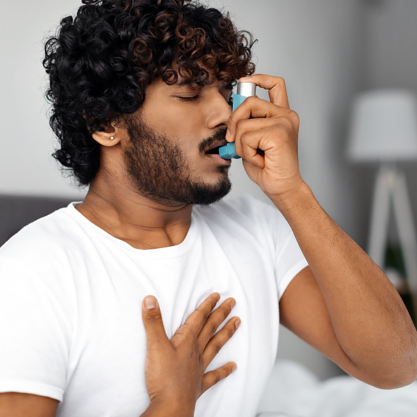 A man using an asthma inhaler