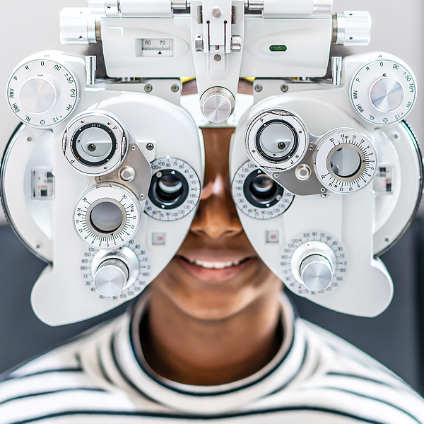 A woman getting an eye exam with a phoropter