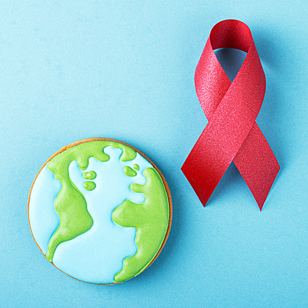A red awareness ribbon and gingerbread planet earth on a blue background