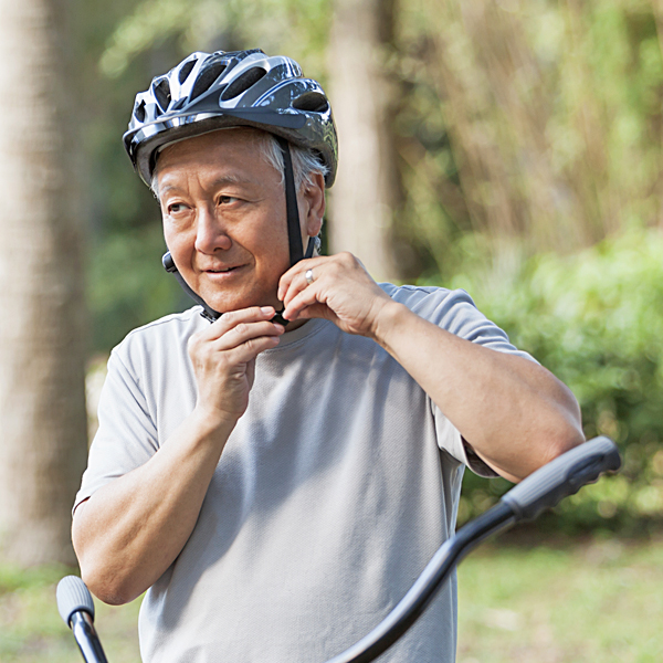 A senior man fastening a bicycle helmet strap