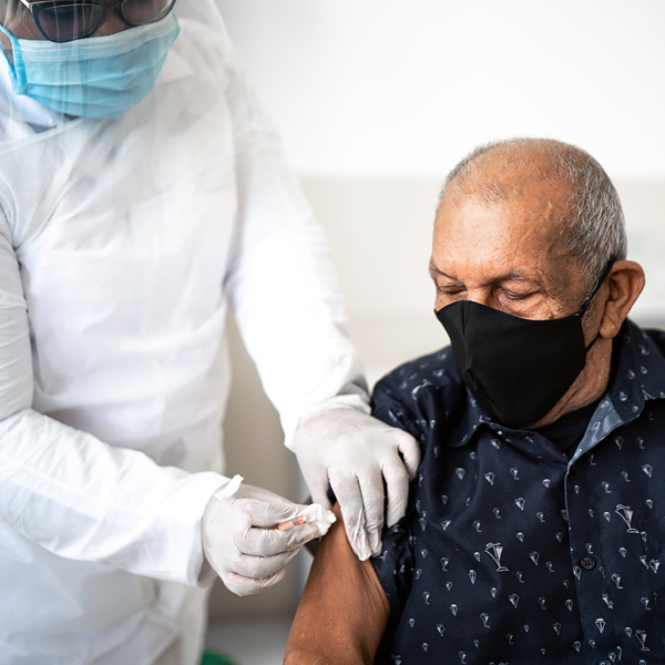 A senior man receiving a vaccine in his arm