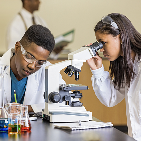 High school students using a microscope and examining slides