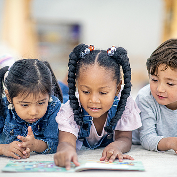 Three children reading a book together