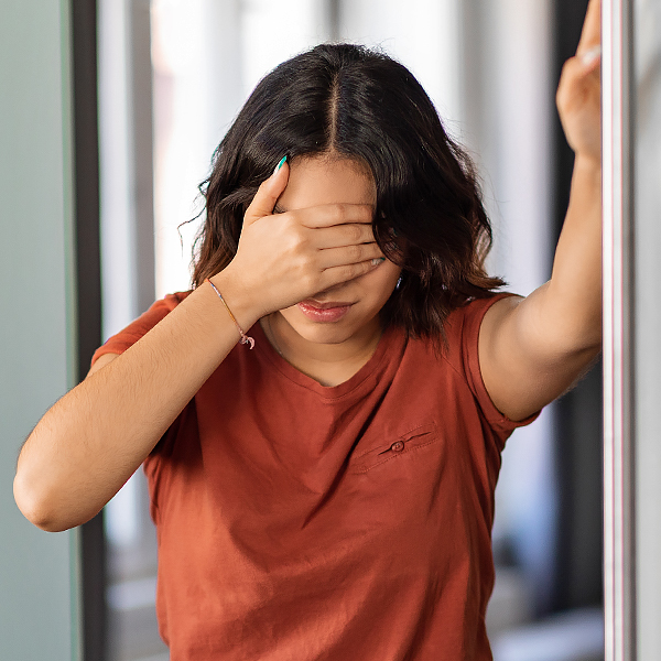 A woman holding her head from lightheadedness or dizziness