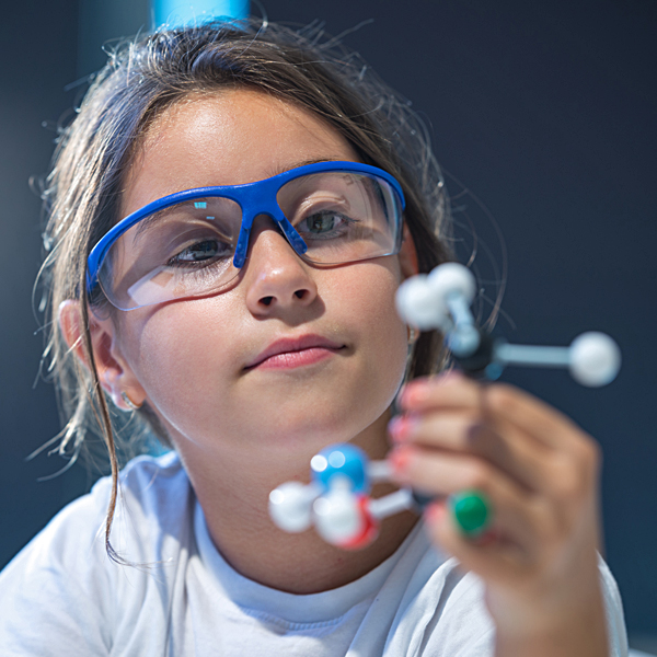 A young girl examining a molecular model