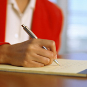 Close-up of a business woman writing on a pad.