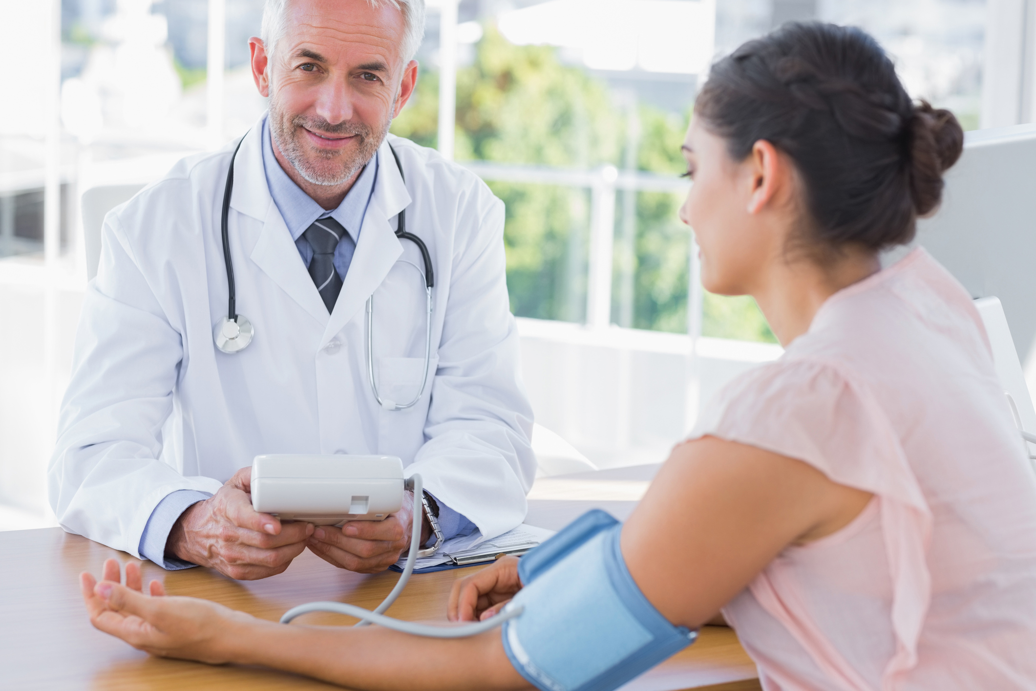 A doctor taking a woman's blood pressure.