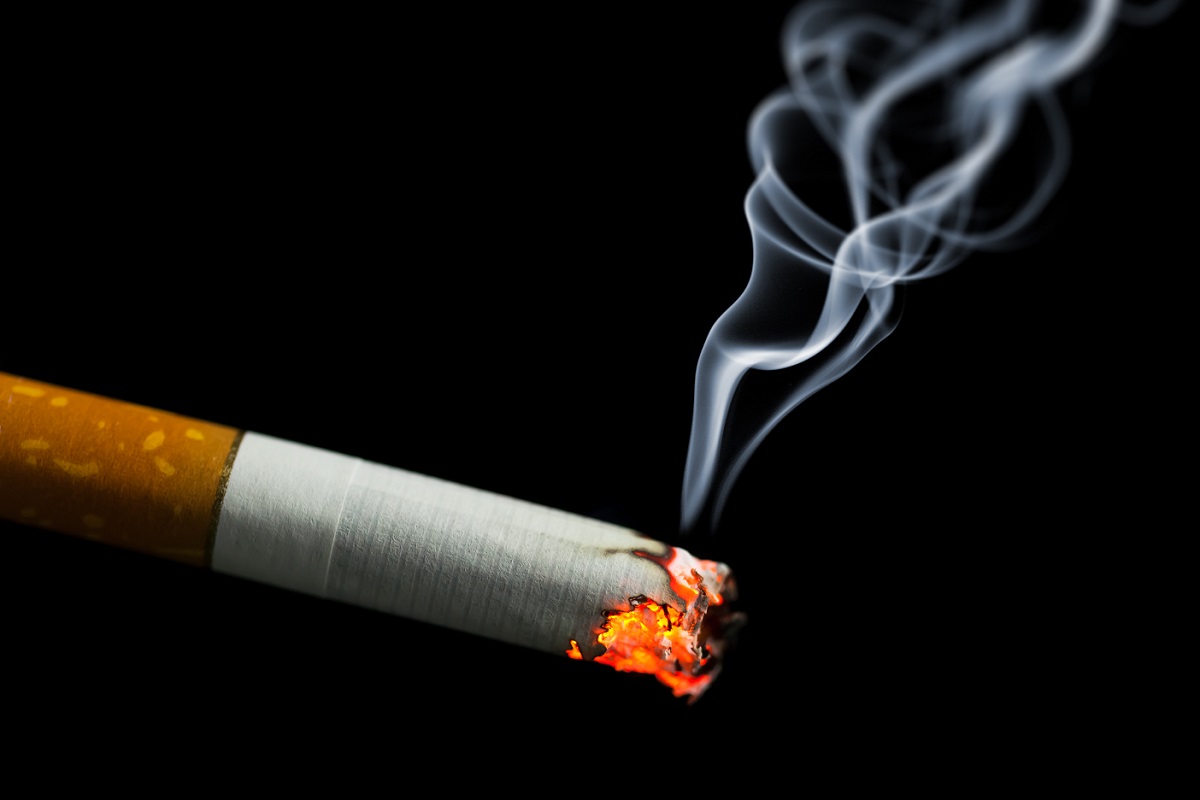 Burning cigarette with smoke.