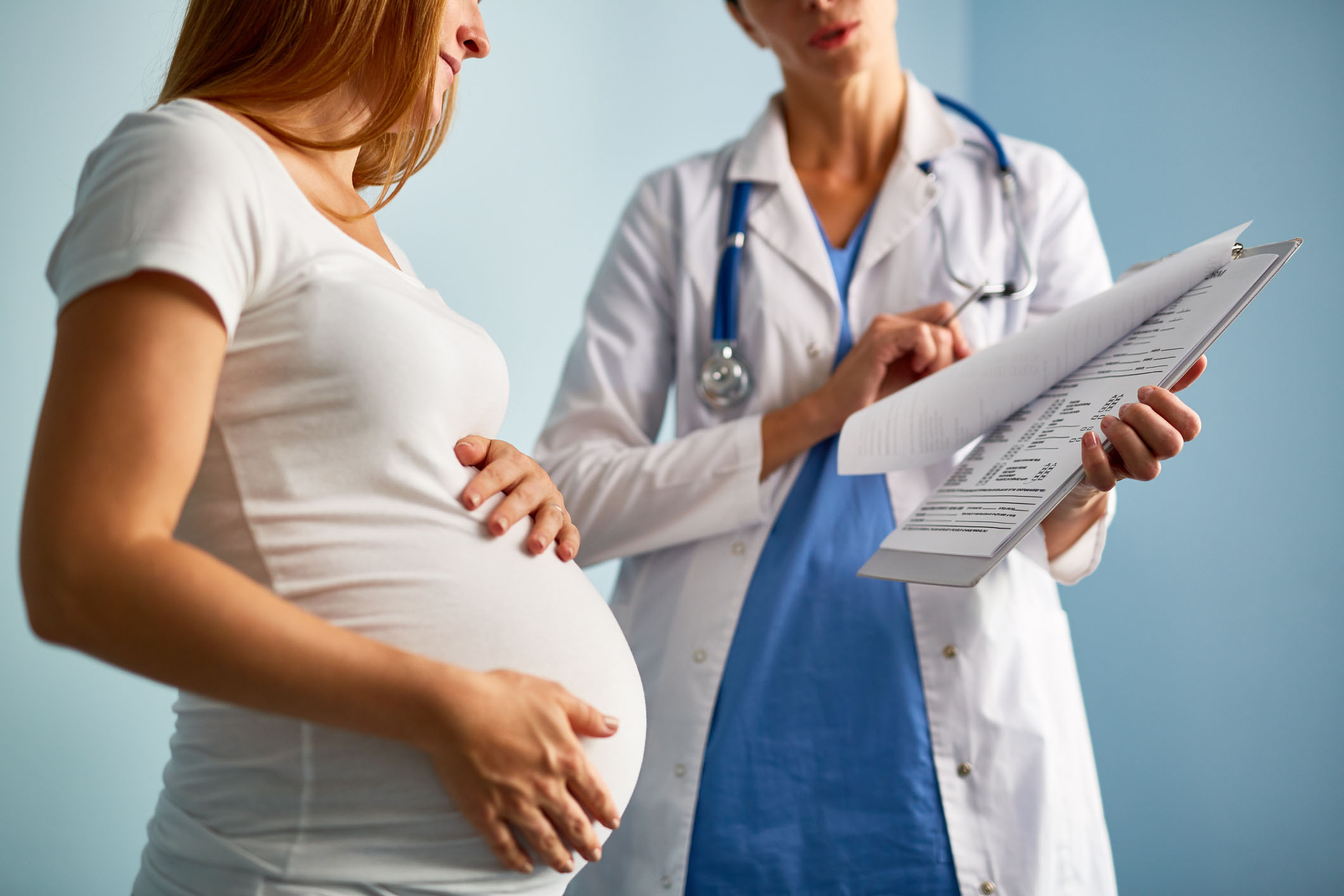 Image of a woman pregnant talking with doctor.