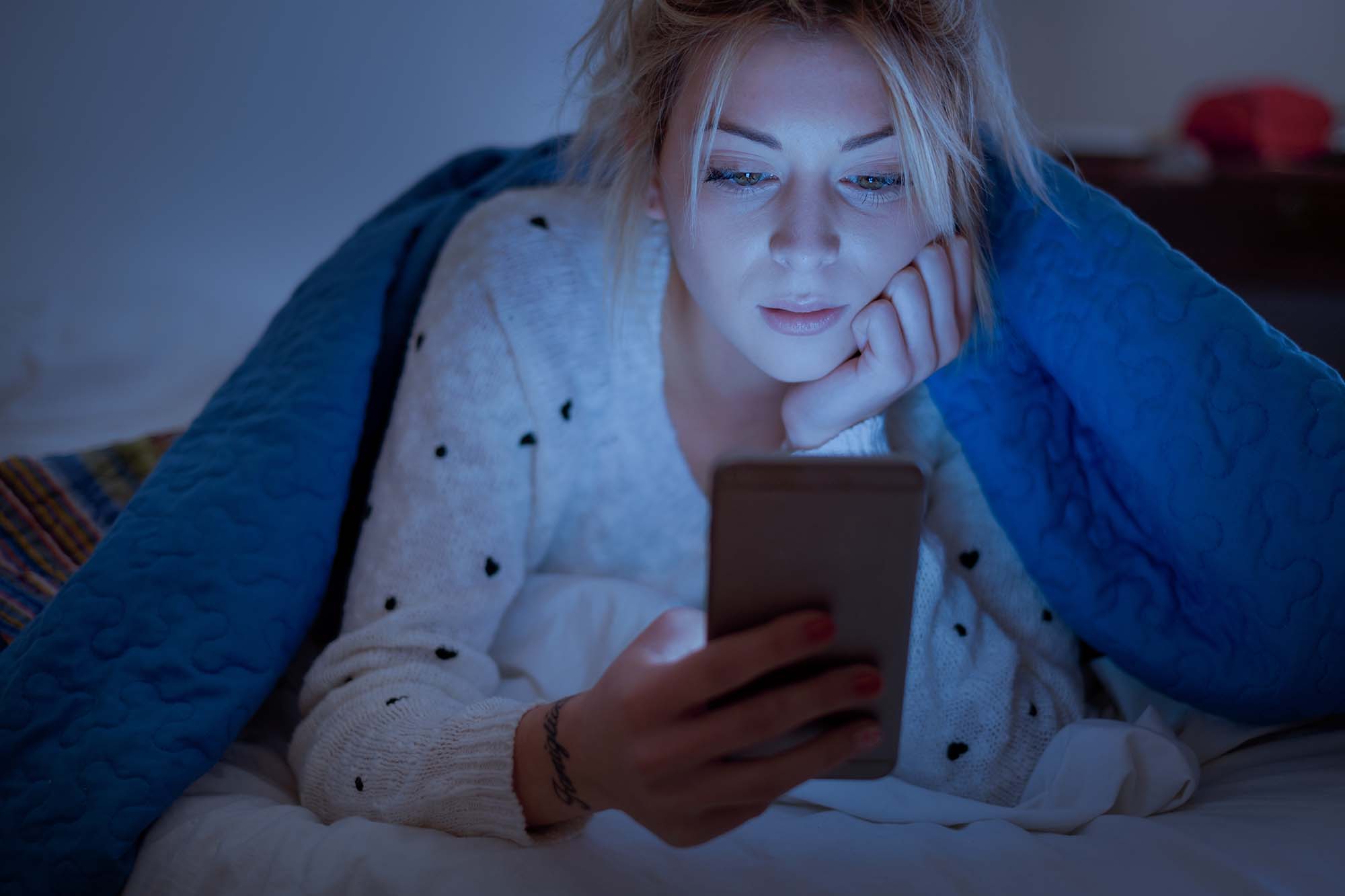 Image of a woman holder her phone at night.