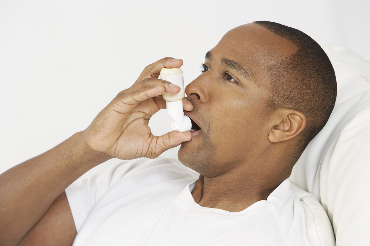 Man using an inhaler.