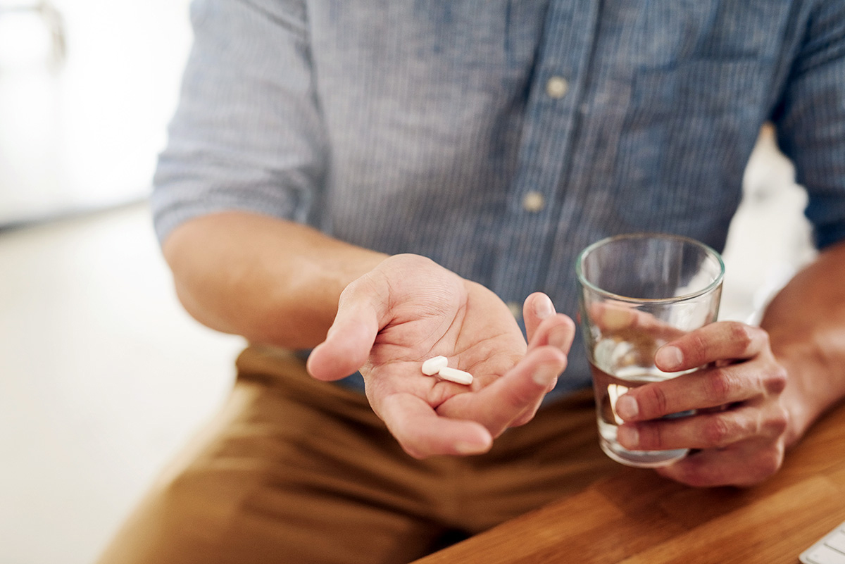 Image of a man taking a pill