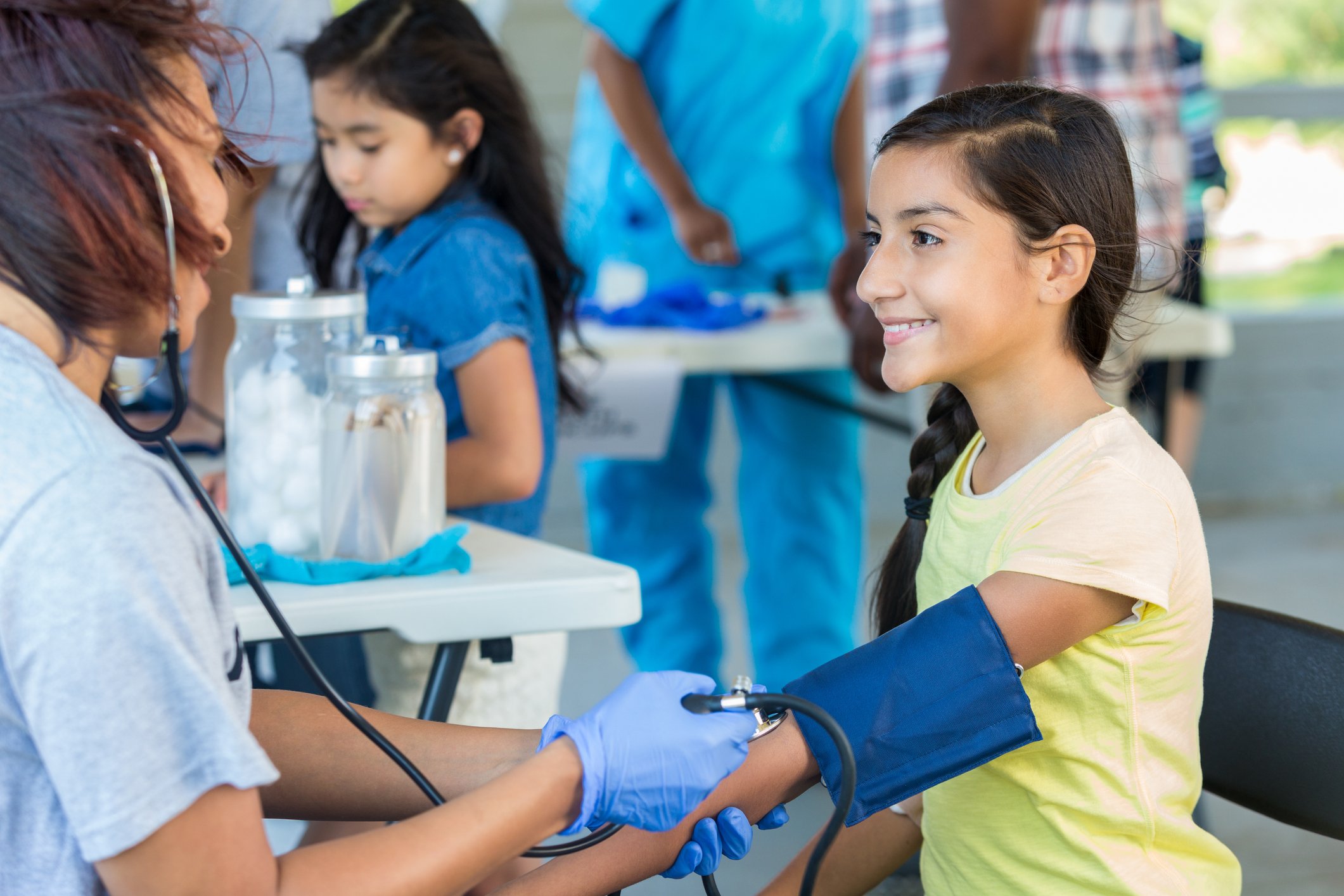 Young Hispanic patient getting blood pressure checked by nurse - stock photo