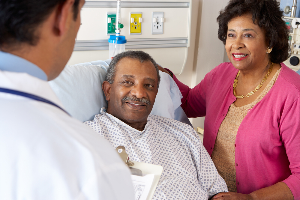 Doctor Talking To Senior Couple On Ward