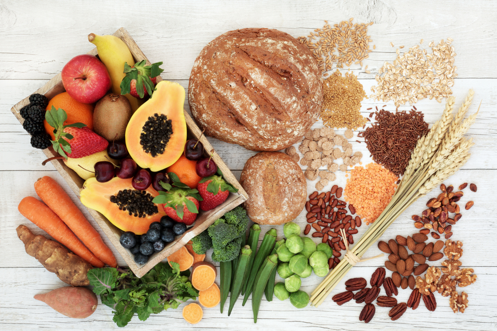 Healthy high fibre diet food concept with legumes, fruit, vegetables, wholegrain bread, cereals, grains, nuts and seeds. Super foods high in antioxidants, anthocyanins, omega 3 and vitamins.