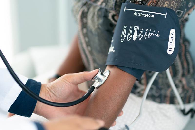 An older woman with a blood pressure cuff on her arm