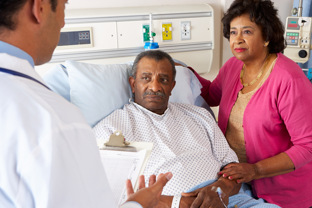 Doctor Talking To Senior Couple On Ward