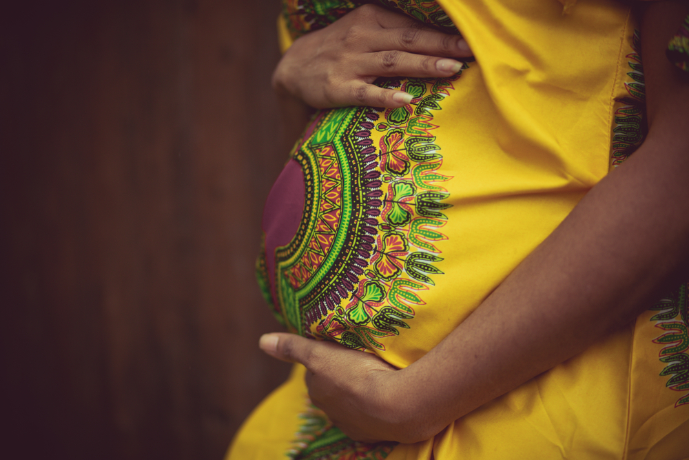 Holding on to her biggest blessing. African American pregnant woman in the park.