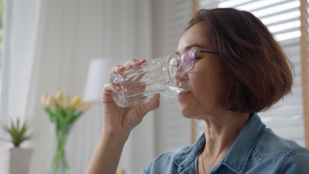 Close-up asia elder people or latin lady hold clean spring cold alkaline water in hand drink sip joy relax help aging face skin benefit for female, routine life balance weight loss by nature taste.