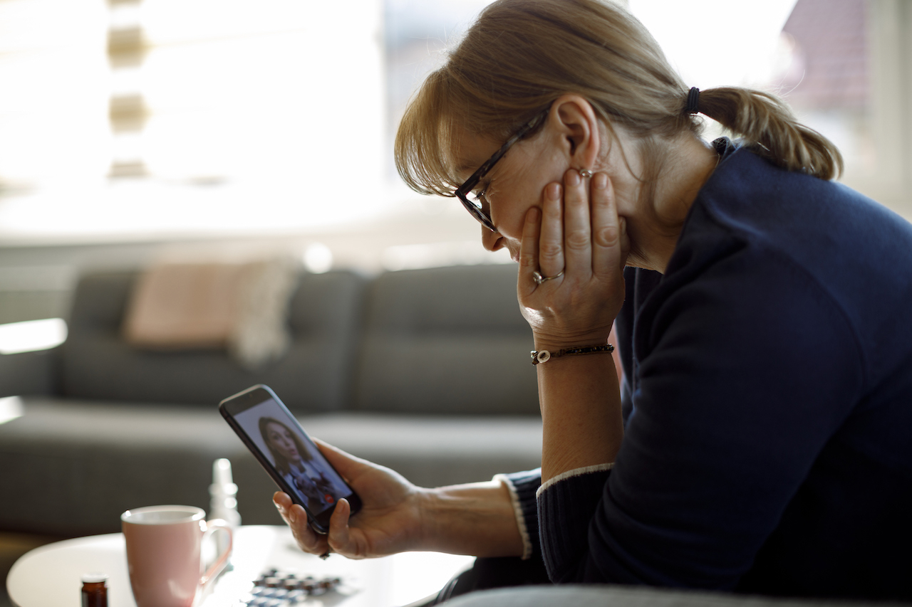 Image of a woman talking with a doctor via smartphone.