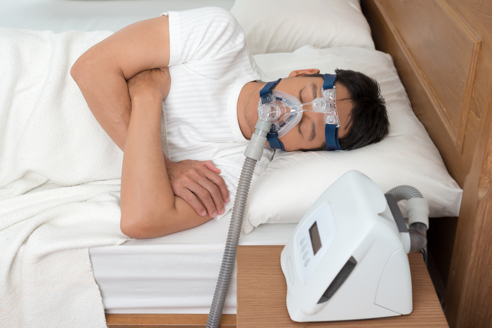 Image of a man wearing a CPAP machine while sleeping