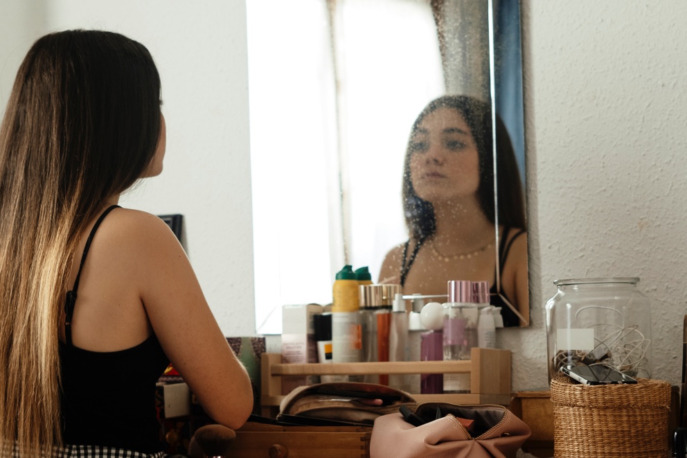 Image of a teenage girl looking at a mirror