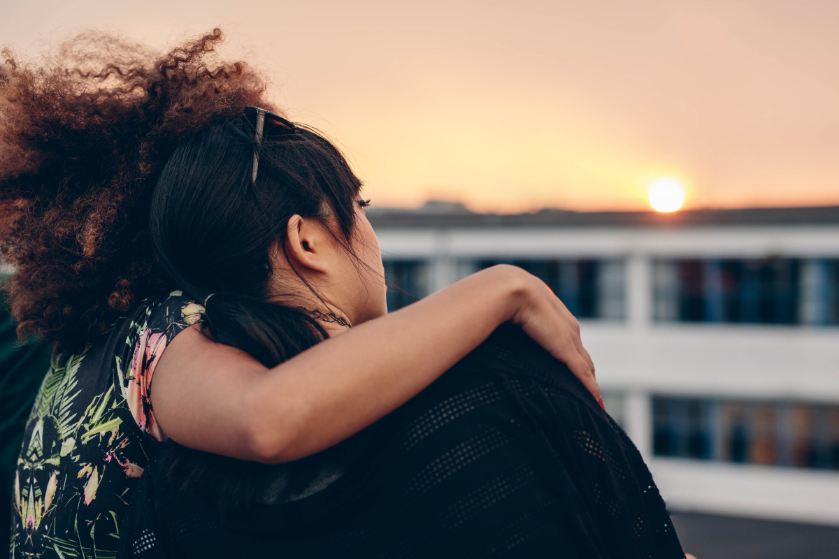 Image of two women sitting on a rooftop