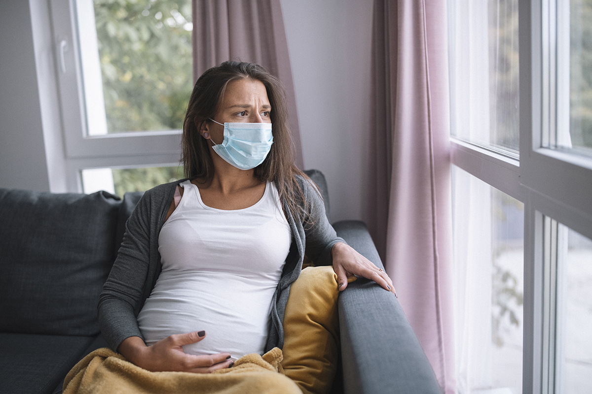 Image of a pregnant person looking out a window