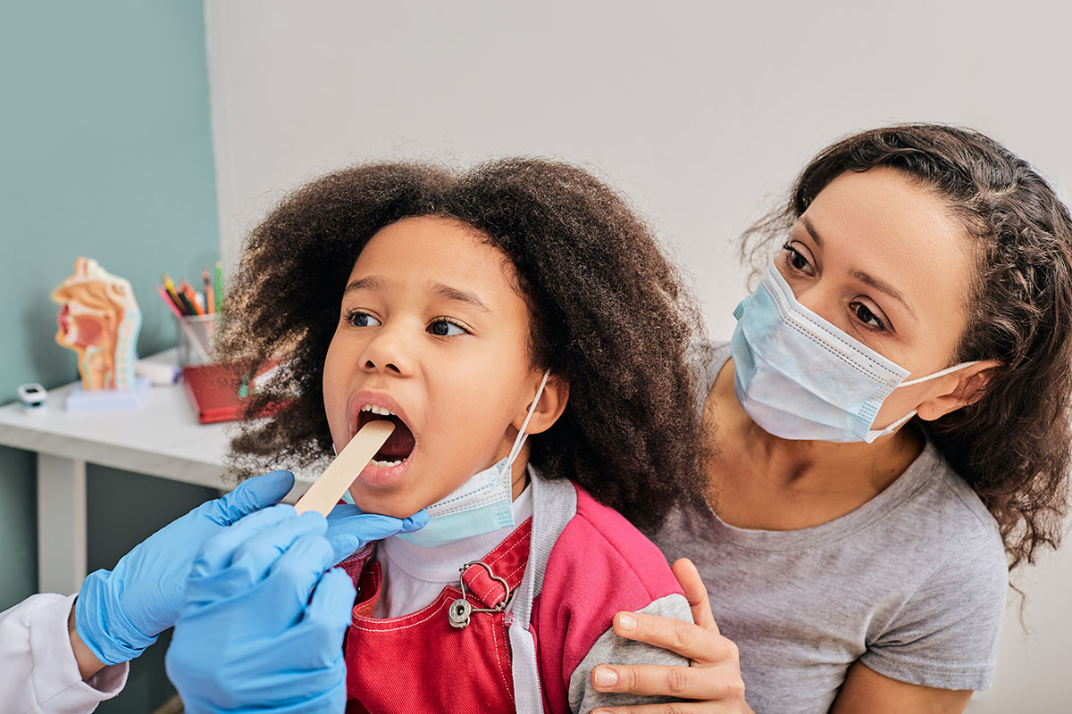 Image of a young girl getting a tonsil exam