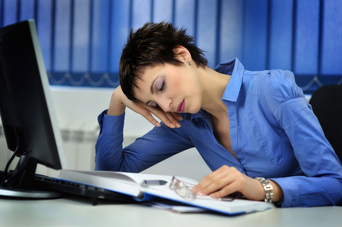 Photo of a woman nodding off at her desk