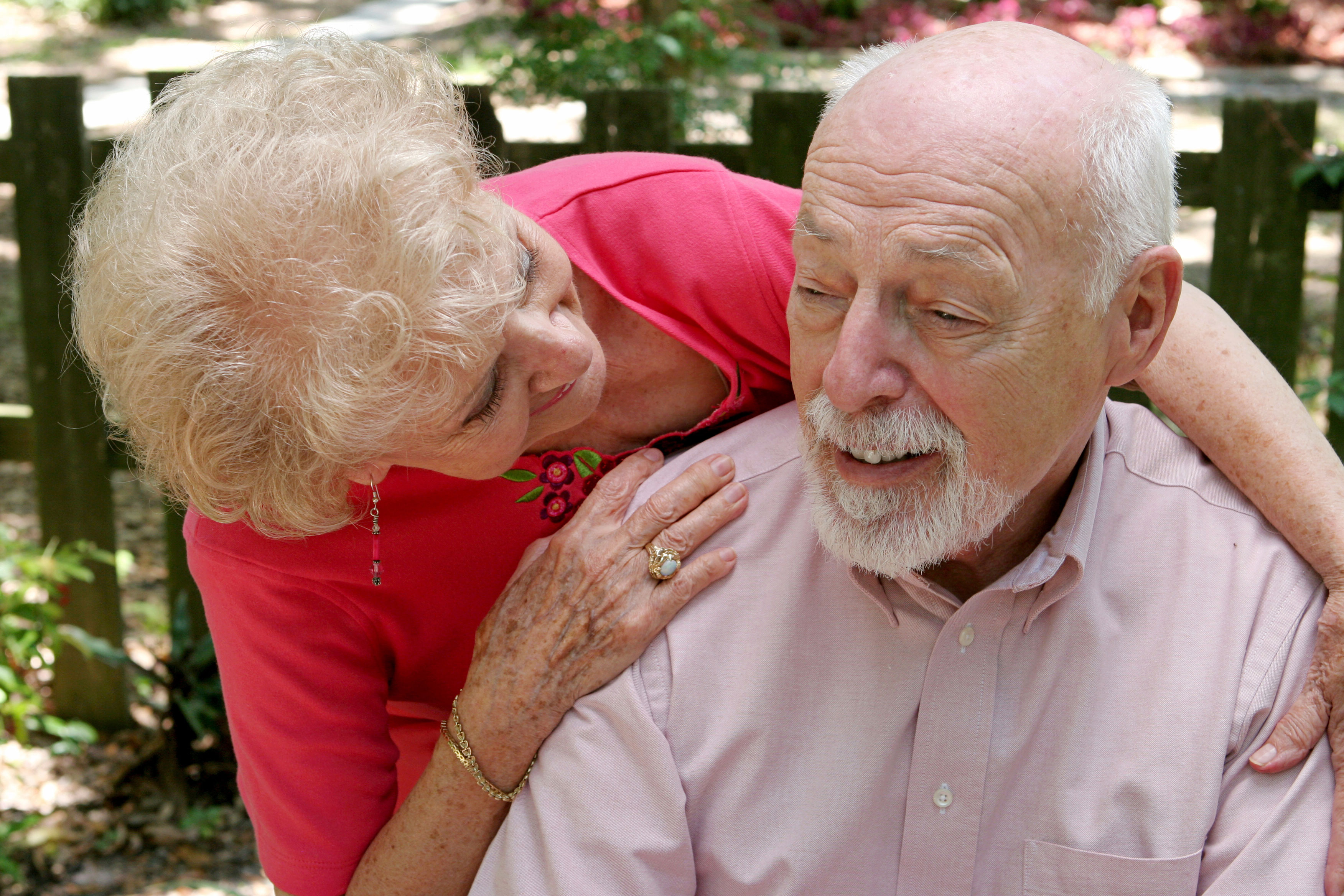 Photo of an older woman caring for her husband