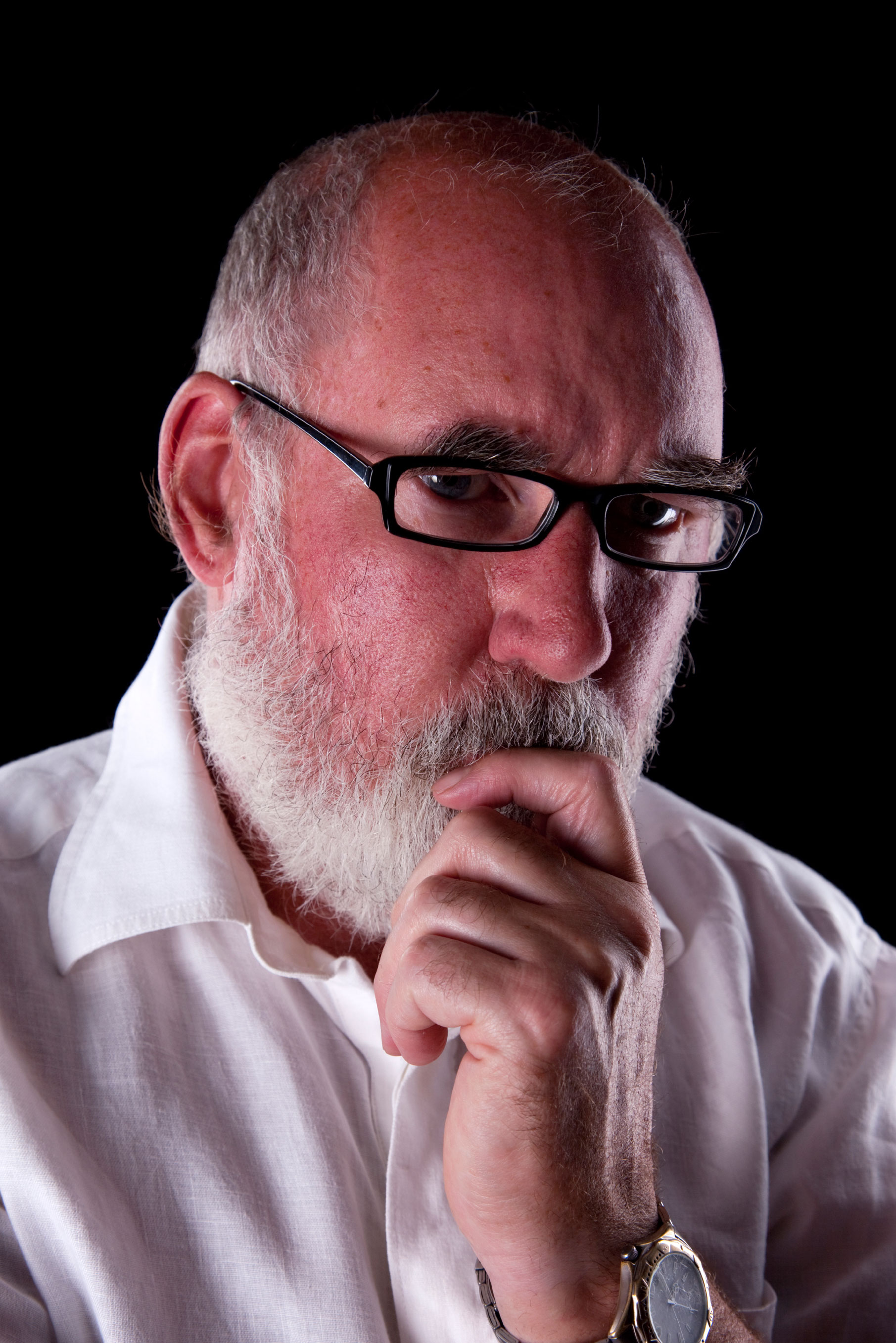 Bearded man in his 60s lost in thought.