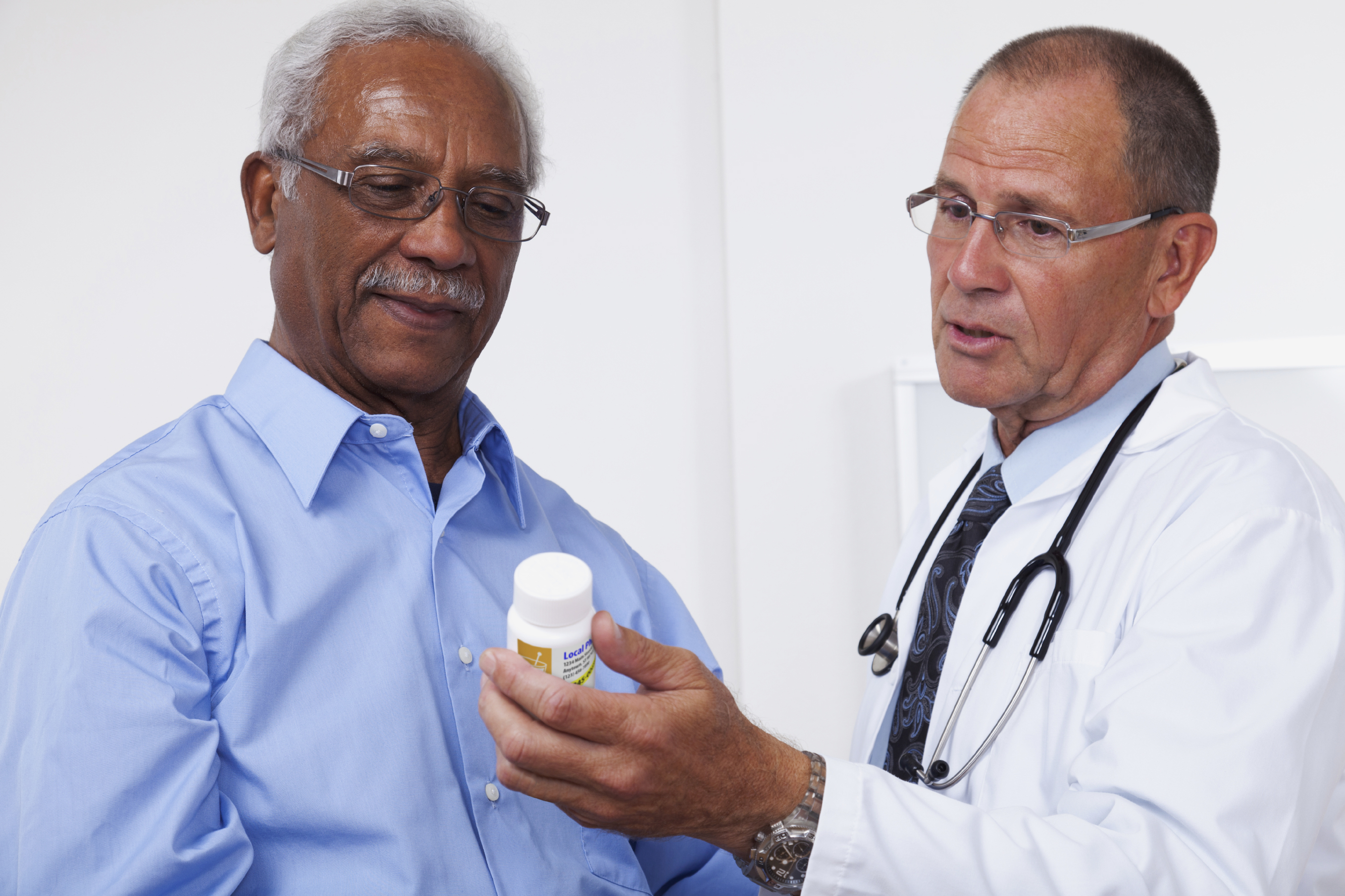 Doctor showing patient prescription bottle.